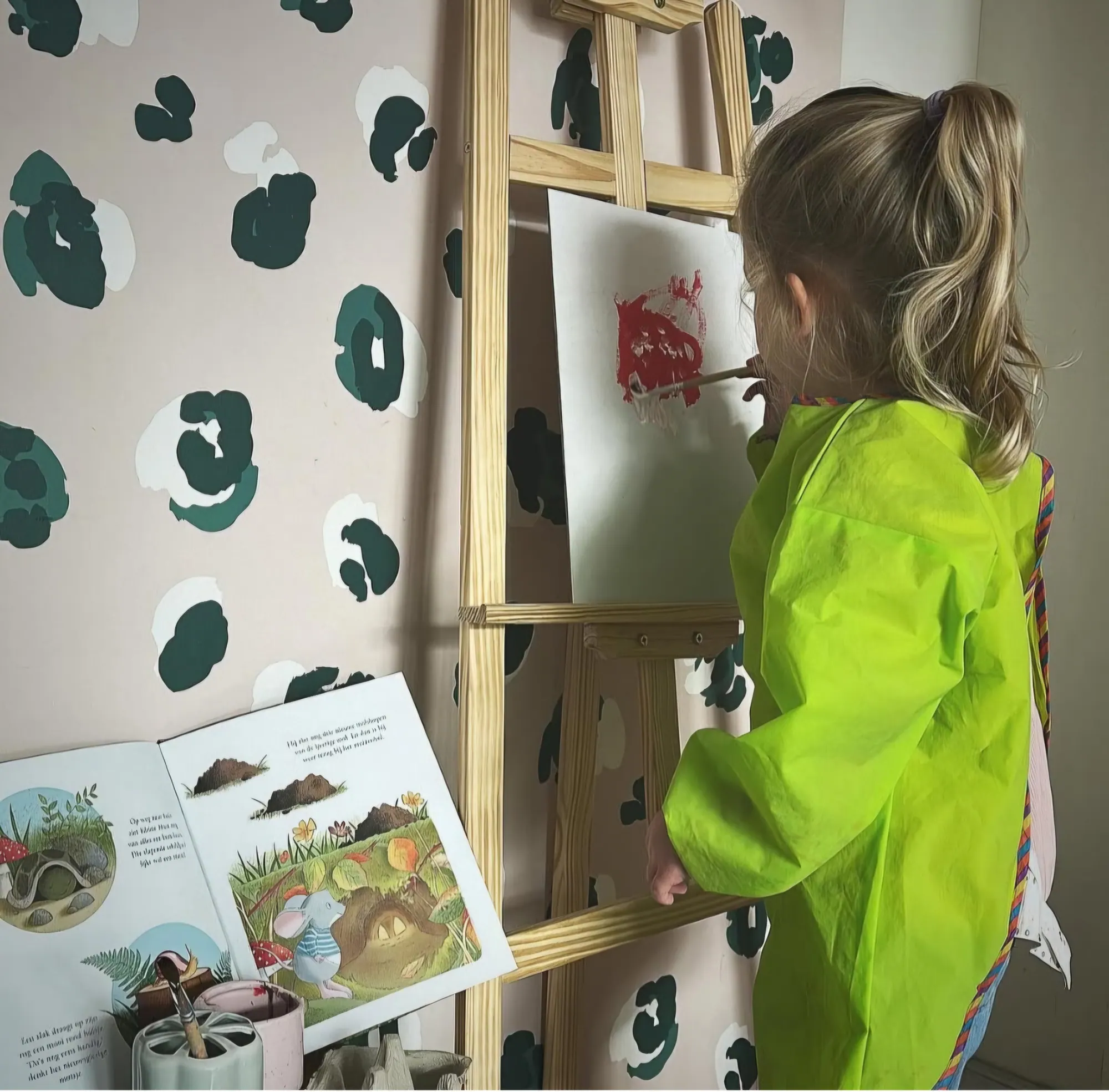 Kind in schort schildert rood op een ezel binnen